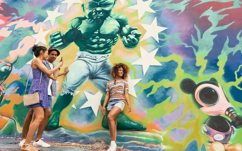 Friends take pics with the Angry Baby painting on Wynwood Walls